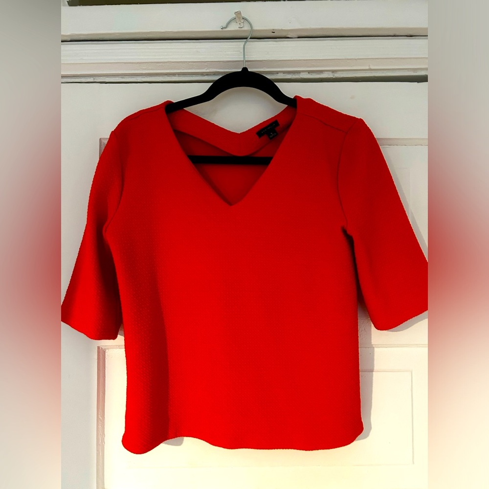 Red/coral structured T-shirt. Fabric has a 3-D small diamond/square pattern.